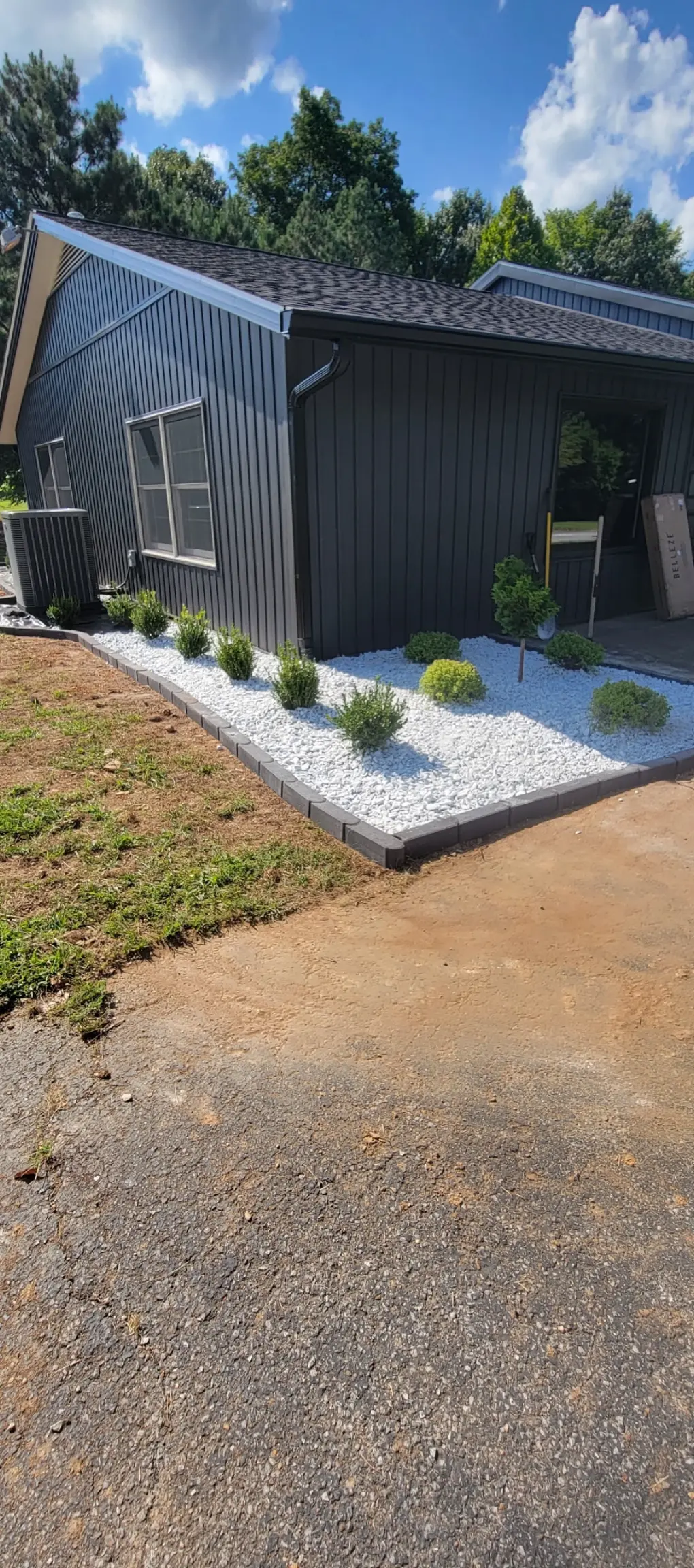 White decorative rock landscape beds with dark paver edging by Luxury Lawns